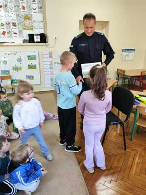 Na zdjęciu widoczny jest policjant z przedszkolakami