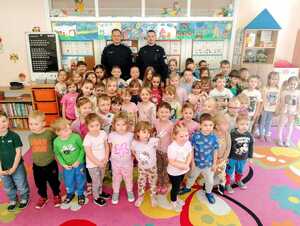 Na zdjęciu widocznych jest dwóch policjantów i przedszkolacy