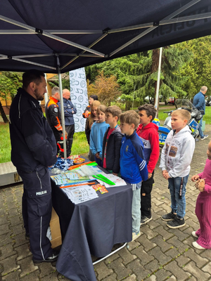 Zdjęcie przedstawia policjanta i dzieci
