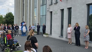 Zdjęcie ukazuje organizatorów, którzy zapowiadają wydarzenie, a dookoła nich widoczni są zgromadzeni ludzie
