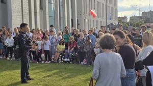 Na zdjęciu widać przewodnika psa policyjnego, który odpowiada na pytania zainteresowanej widowni