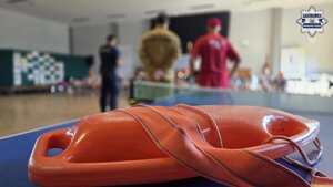 Widoczna jest leżąca bojka ratownicza, a w tle zaproszeni goście