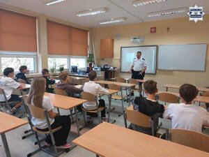 Na zdjęciu widoczna jest sala, na której znajdują się uczniowie i dzielnicowy