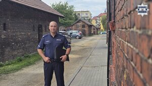 Na zdjęciu widoczny jest sierżant Marcin Drewniok na tle starych budynków