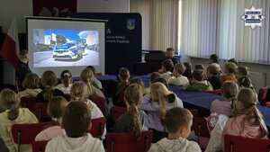 Zdjęcie przedstawia zebranych uczniów oraz dzielnicowego podczas oglądania filmiku kampanii